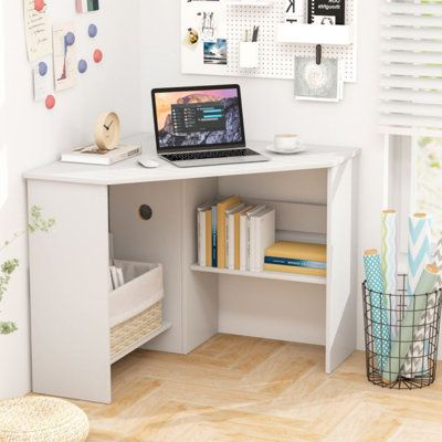 a laptop computer sitting on top of a white desk next to a shelf filled with books