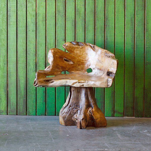 a piece of wood sitting on top of a cement floor next to a green wall