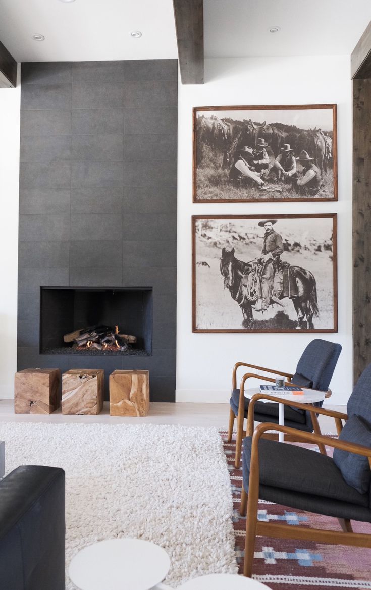 a living room with two pictures on the wall and a fire place in the corner