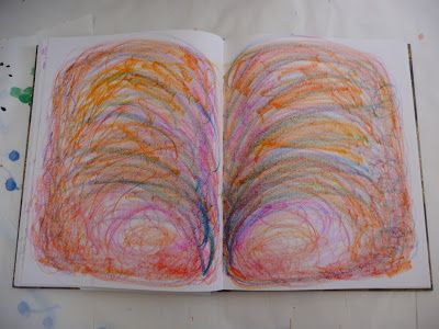 an open book with colored crayons on it