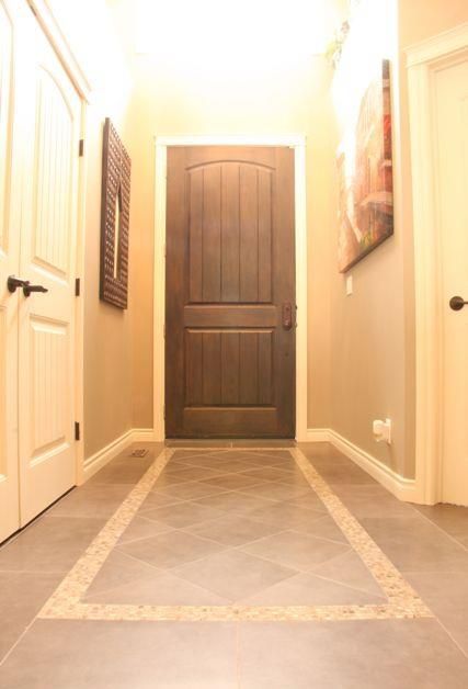 an empty hallway with two doors leading to another room and the light coming in from above