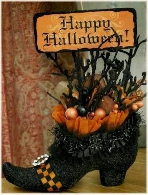 a black boot with orange and black decorations on it's side, next to a sign that says happy halloween