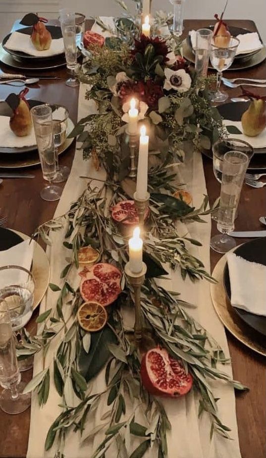 the table is set with fruit and candles for an elegant touch to the dining room