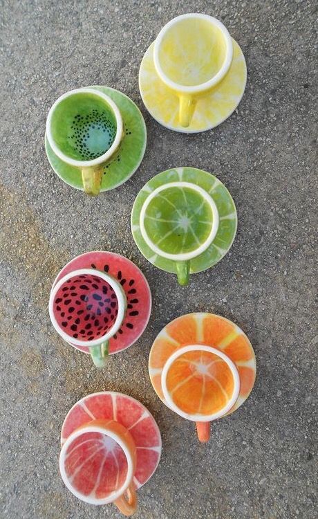 fruit shaped cups with juice in them sitting on the ground