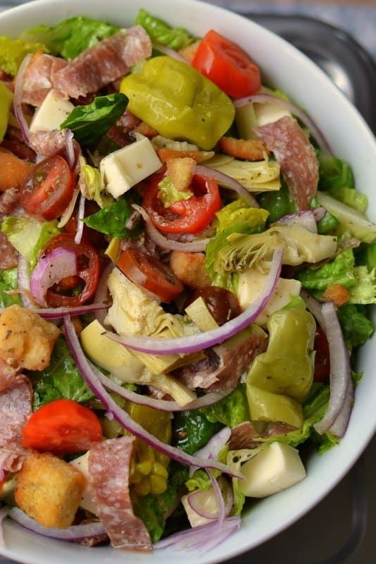 a white bowl filled with lots of different types of food on top of a table