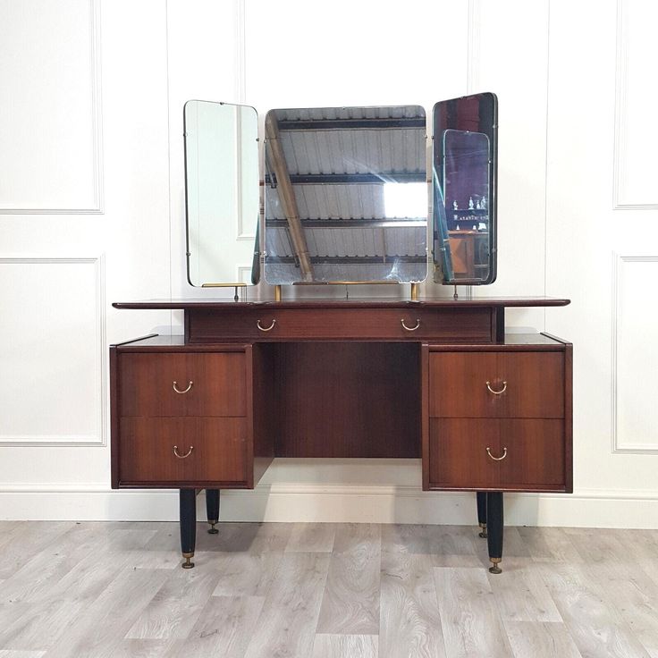 a wooden desk with two drawers and a large mirror on it's back end