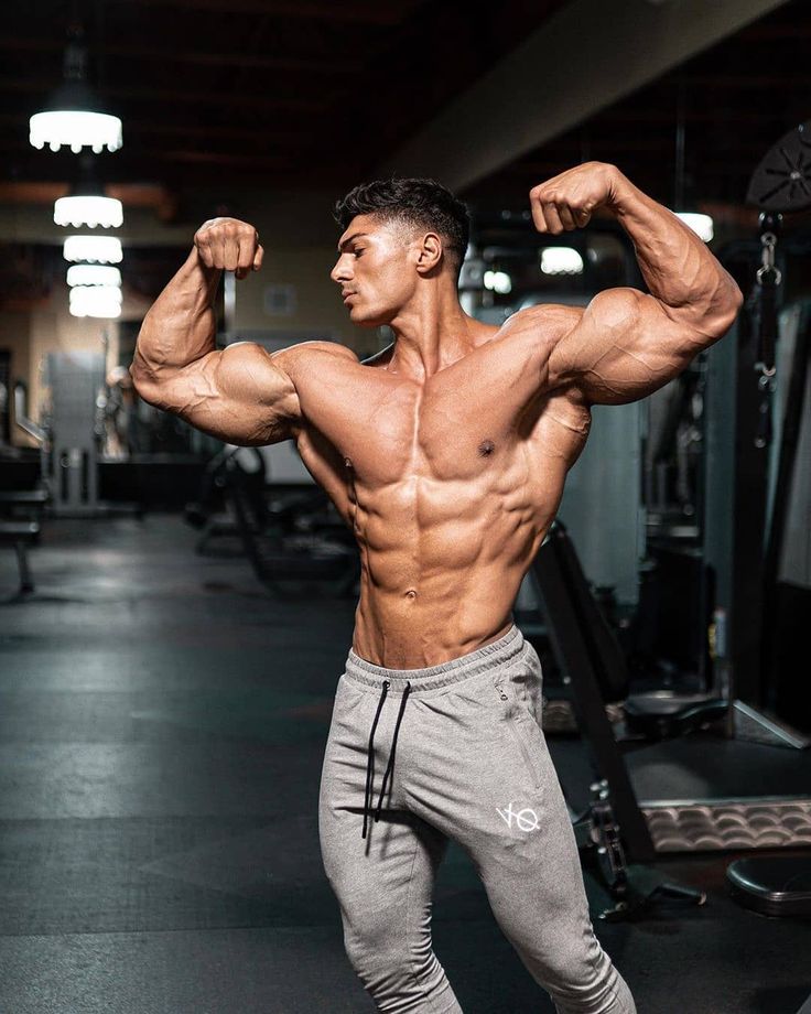 a man flexing his muscles in the gym