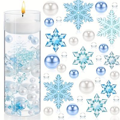 a candle and snowflakes are next to a glass filled with water