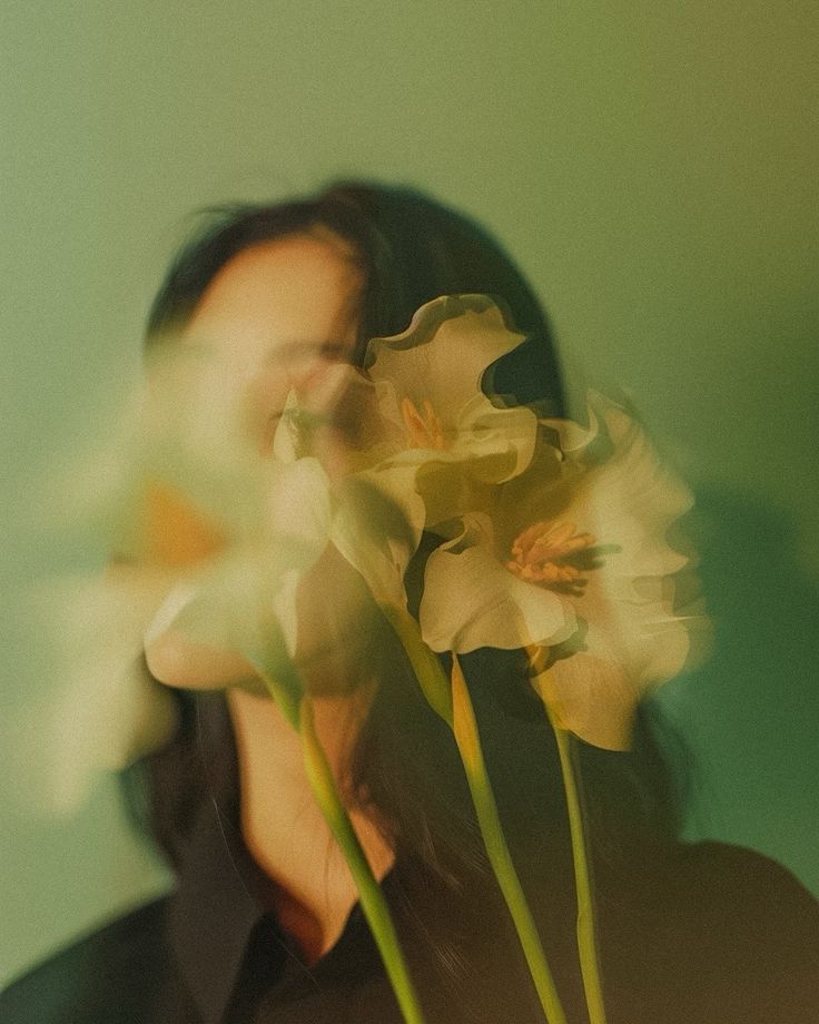 a woman holding flowers in front of her face