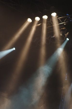 three spotlights shine brightly on a stage with lights coming from the top and bottom