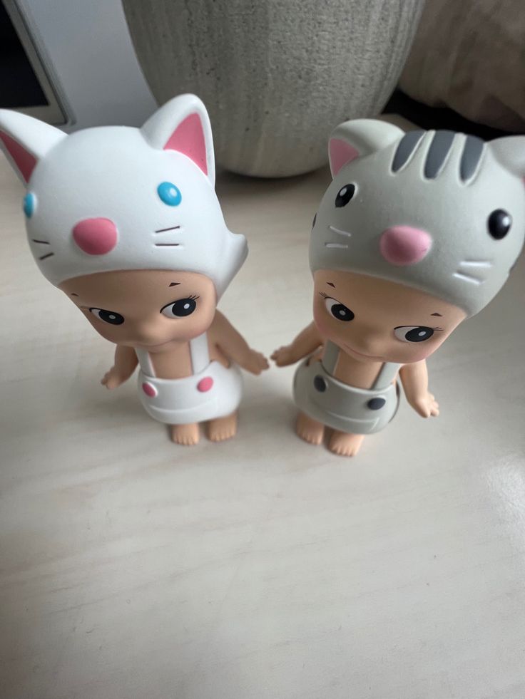 two toy cats are standing next to each other