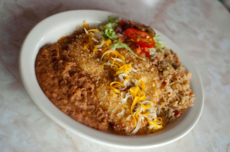 a white bowl filled with food on top of a table