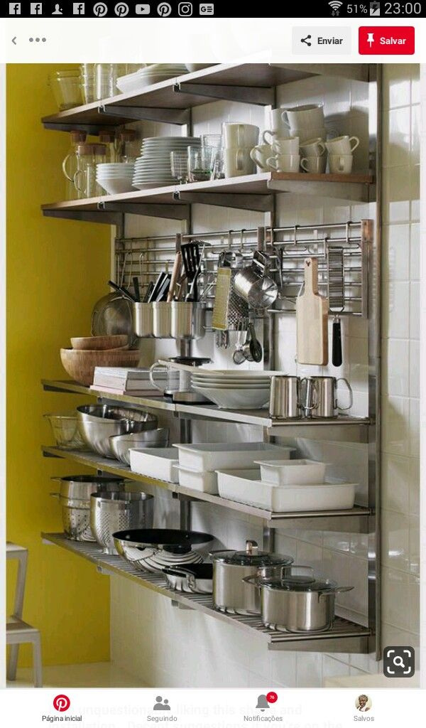 the shelves are full of dishes and pans in the kitchen, with yellow walls