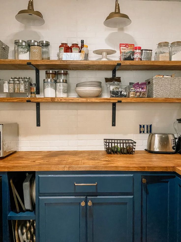 a kitchen with blue cabinets and open shelves