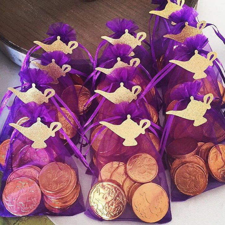 purple and gold bags filled with coins on top of a table