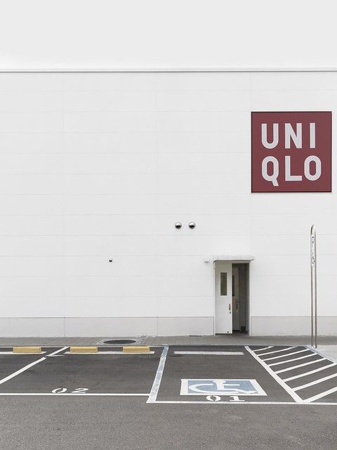 an empty parking lot in front of a building with a sign that reads uniqlo