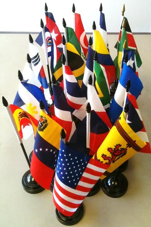 a bunch of flags sitting on top of a table next to each other in a vase