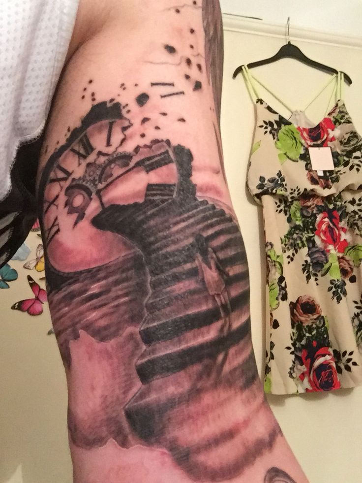 a man's arm with a clock and watercolor painting on it, next to a dress