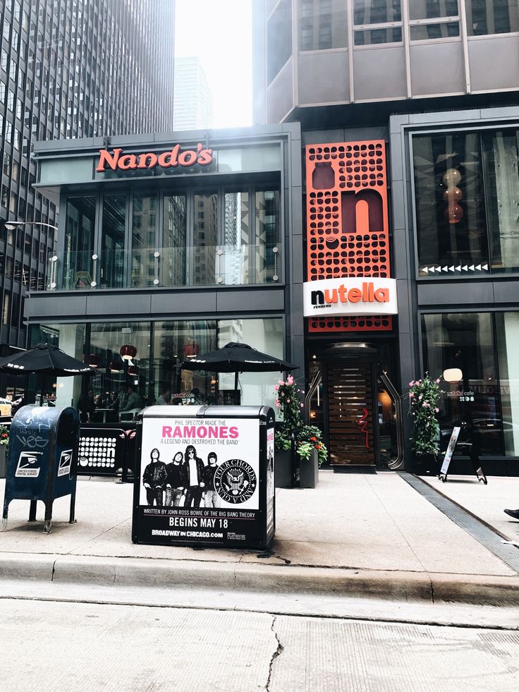 the entrance to nando's restaurant in new york city, with chairs and tables outside