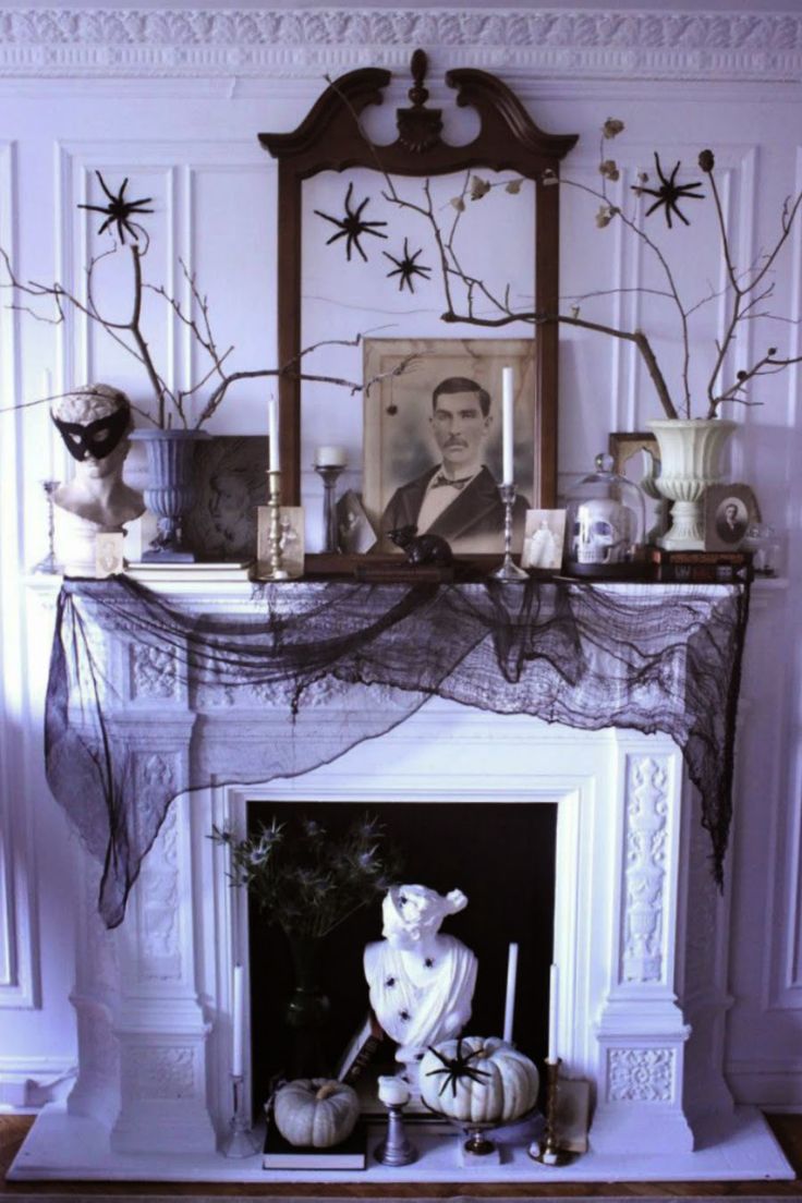 a mantel with a fireplace decorated for halloween