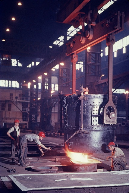 two men working in a factory with steel