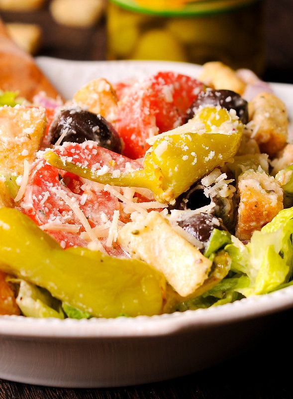 a salad with olives, tomatoes and other vegetables