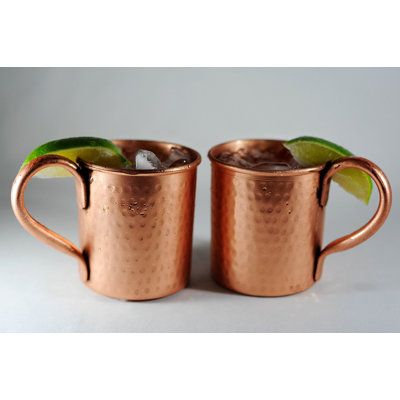 two copper mugs with green leaves in them