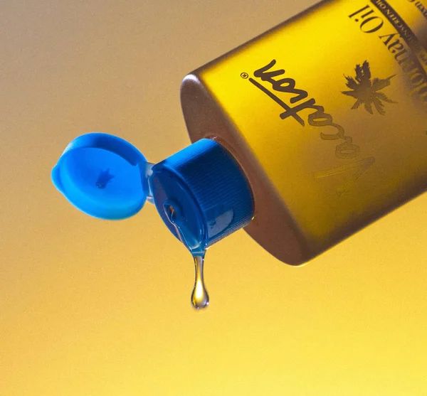 a bottle of mustard is being poured into the air with a blue dropper on it