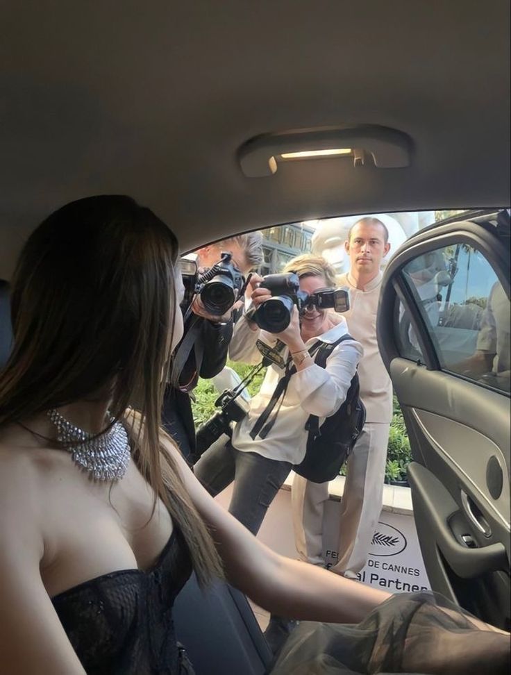 a woman in a car with cameras taking pictures