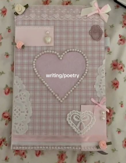 a pink and white book with hearts on the cover, surrounded by lace and flowers