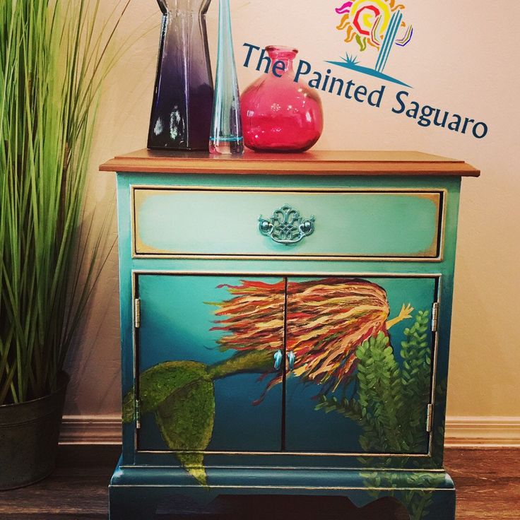 an artistic painted dresser next to a potted plant