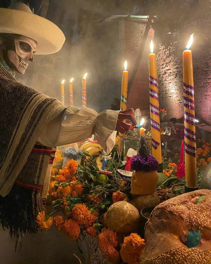 a display with candles and skulls in the center, surrounded by orange flowers and other decorations