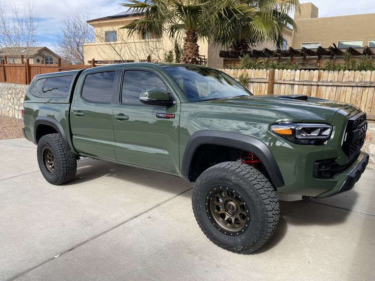 a green truck parked in front of a house