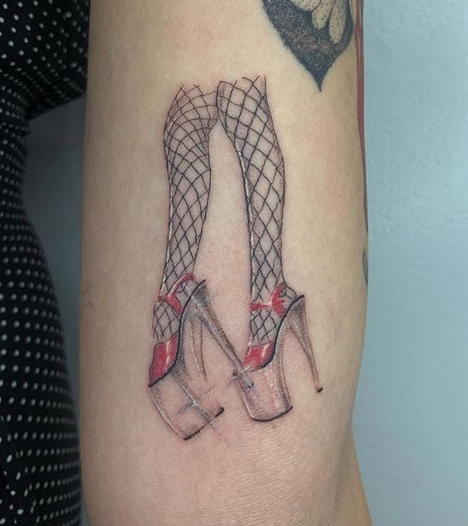 a woman's thigh with a pair of high heeled shoes tattooed on it