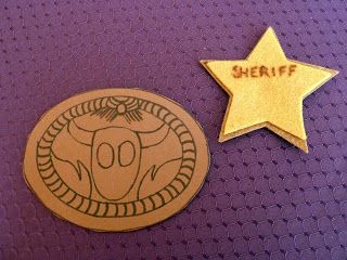 two badges with the words sheriff and a star on them are sitting on a purple surface