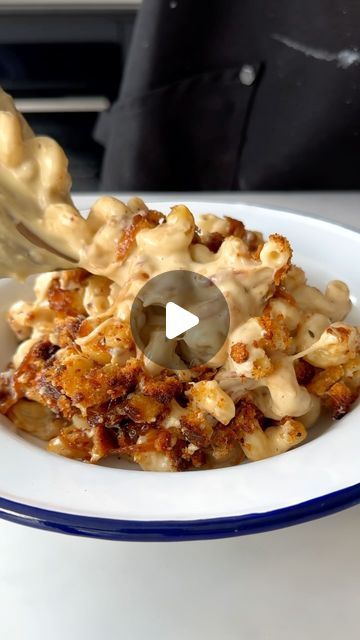 a white bowl filled with macaroni and cheese on top of a blue and white plate