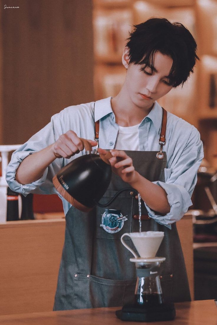 a young man pouring coffee into a cup