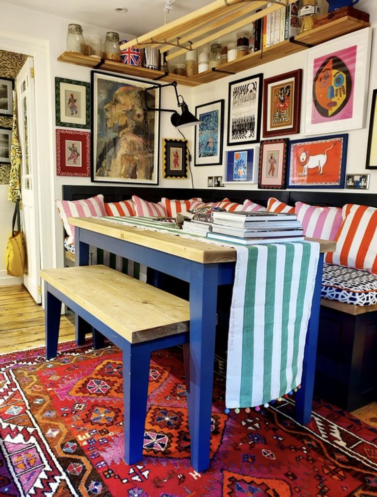 a dining room with colorful rugs and pictures on the wall