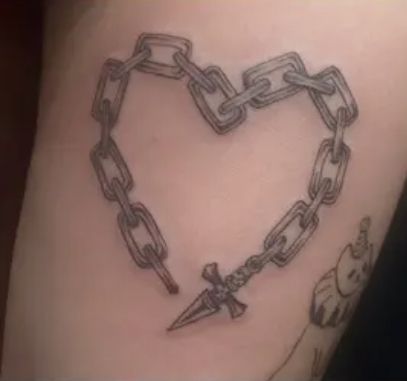 a heart shaped tattoo with chains attached to it