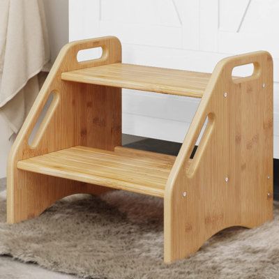 a wooden step stool sitting on top of a rug