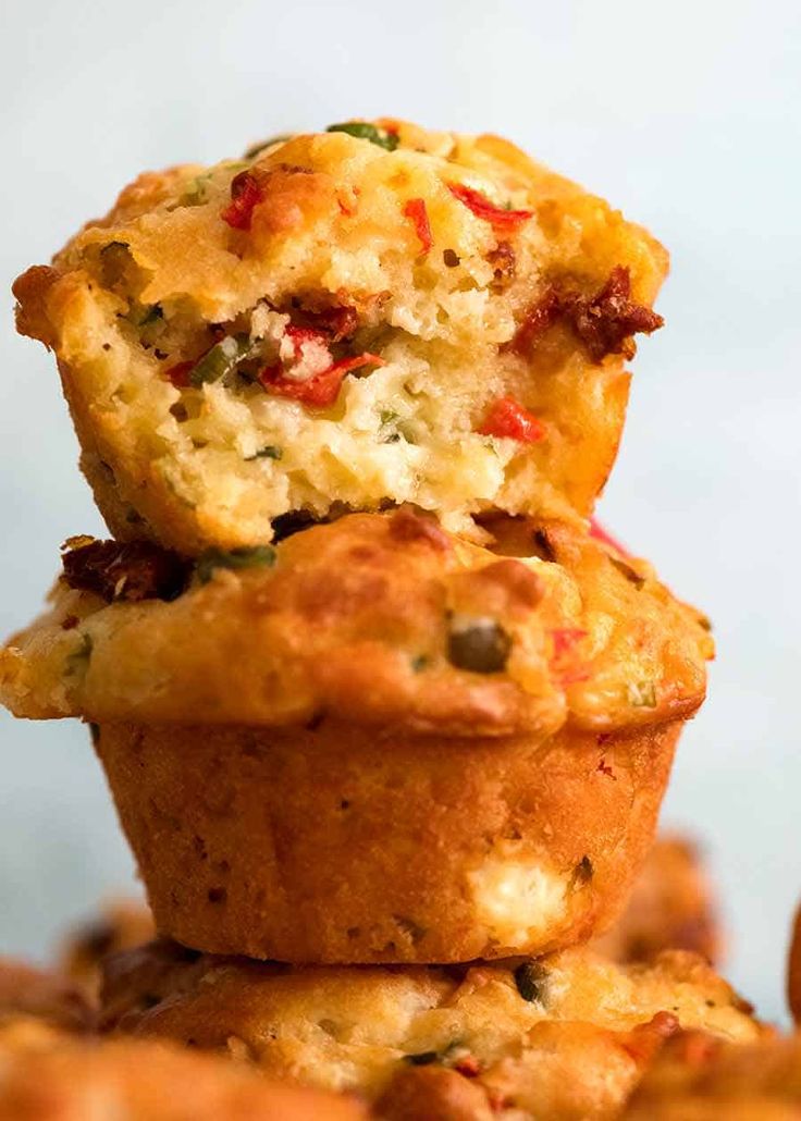 several muffins stacked on top of each other with one bite taken out of it