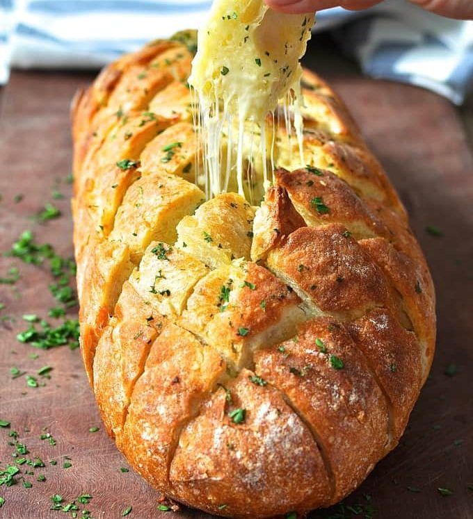 a loaf of bread is being drizzled with cheese