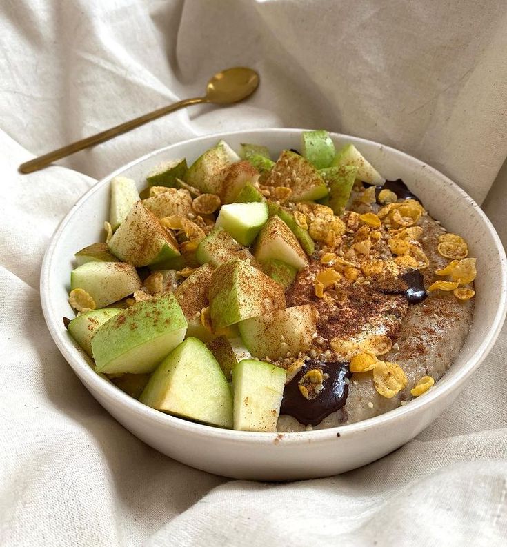 a bowl filled with oatmeal and fruit on top of a white cloth