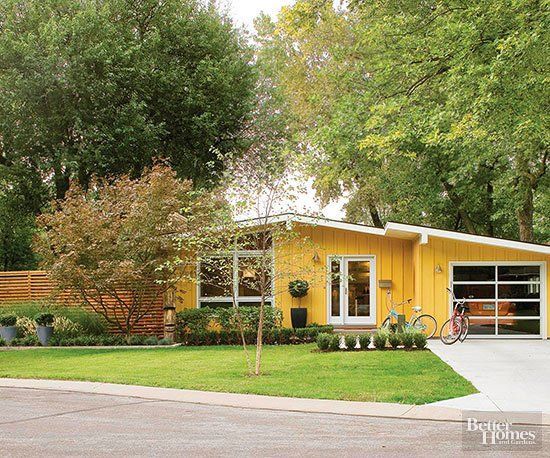 a yellow house with trees in the background