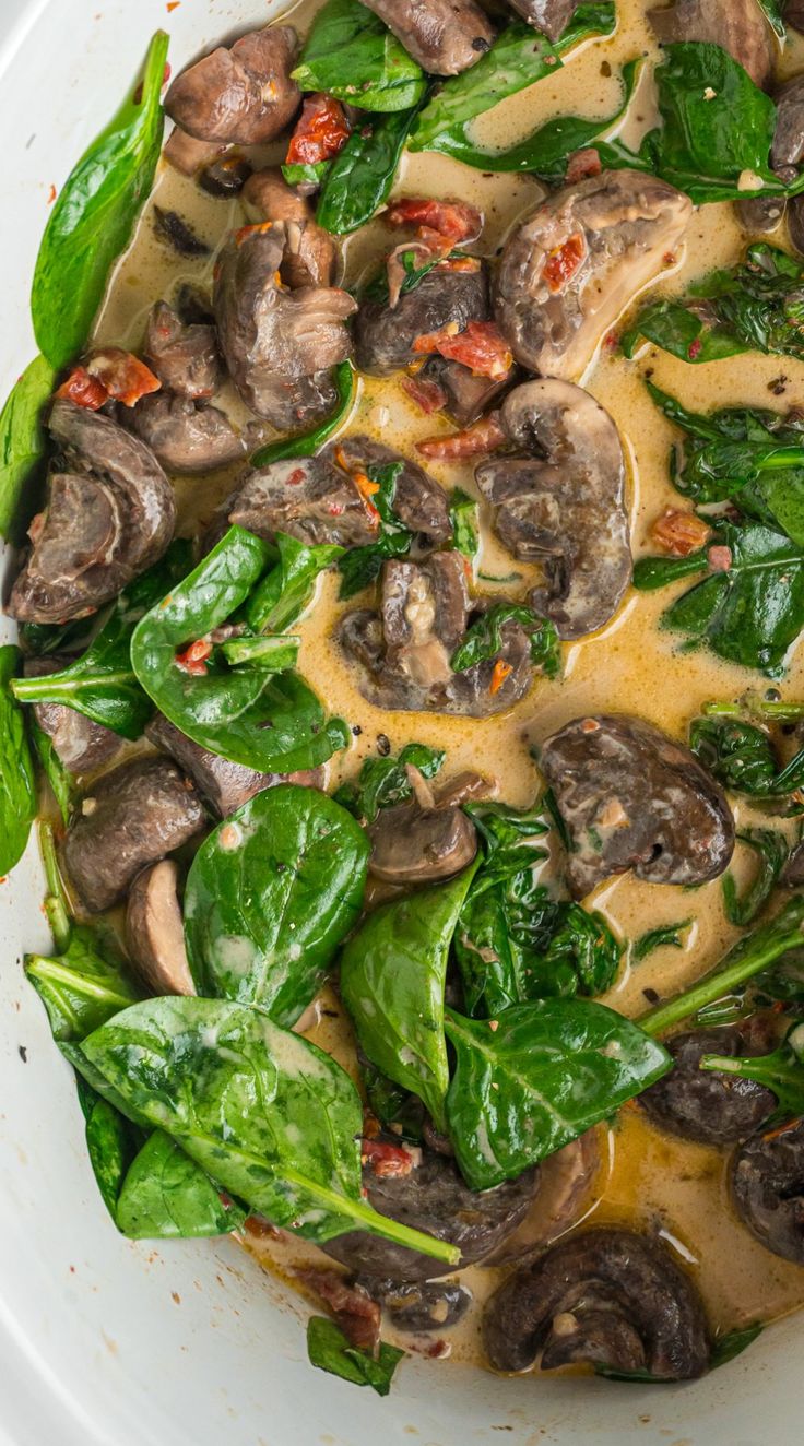 a white bowl filled with mushrooms and spinach