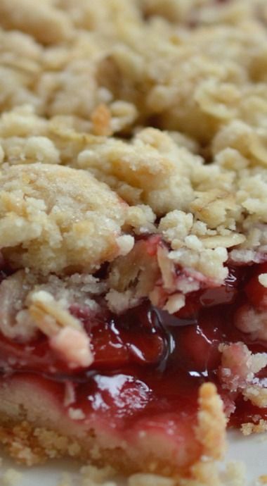 a close up of a piece of pie on a plate with crumbled toppings