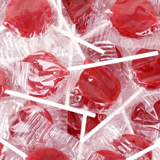 red candies are wrapped in clear plastic and have white sticks sticking out of them