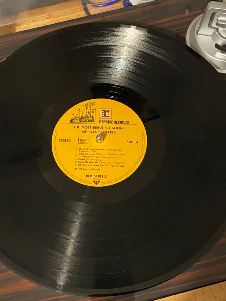 an old record player sitting on top of a wooden table