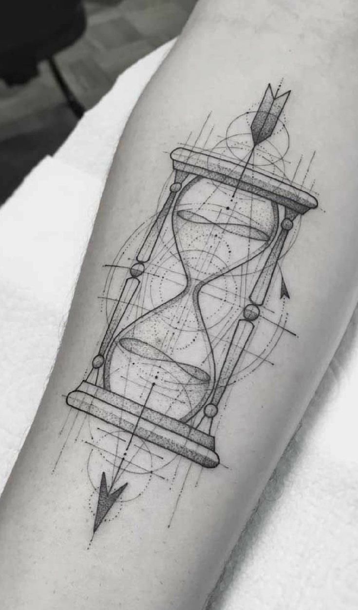 a black and white tattoo with an hourglass on the left arm, which is drawn in