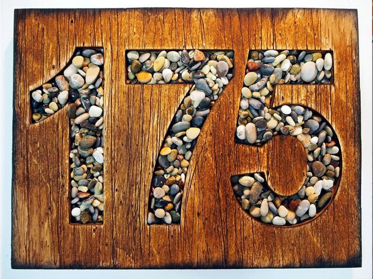 a wooden sign with rocks in the shape of number seventy seven on it's side